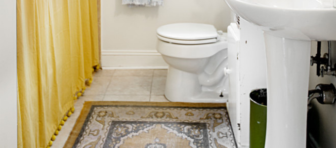 gele gordijn en boho tapijt in badkamer